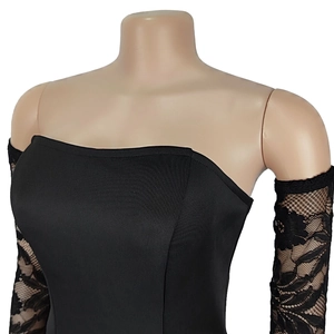 Détail des manches en dentelle florale noire et du tissu en maille sur le haut bustier