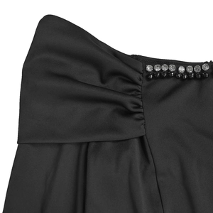 Detailed close-up of side ruching and elegant beadwork on a black evening dress