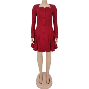 Detail view of deep red long sleeve dress featuring V-neckline and pleated hemline