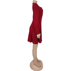 Detailed side view of a red V-neck dress featuring long sleeves and a pleated skirt design