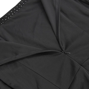 Close-up of invisible zipper and silver stud details on a black elegant evening dress