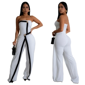 Detail view of a white strapless jumpsuit with black geometric piping and gold buttons