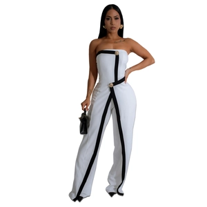 Detail of white strapless jumpsuit with black contrast lines and gold vintage buttons