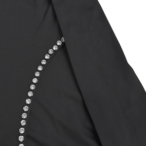 Detail shot of black evening dress featuring delicate crystal rhinestones along the curved seam
