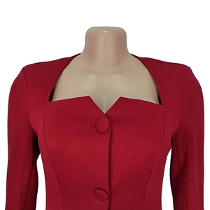 Detailed close-up of deep red dress with square neckline and fabric-covered buttons