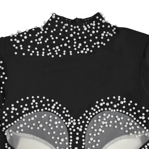 Close-up of elegant black dress featuring white faux pearl beads and sheer mesh panels