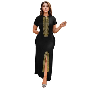 Détail de la robe noire avec motifs de feuilles dorées et fente latérale avec strass