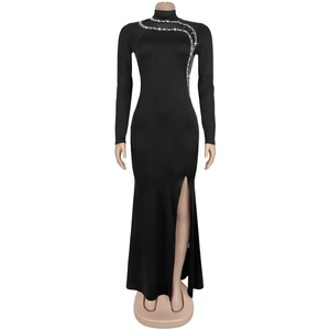 Détail d'une robe noire à col haut, manches longues, strass et fente latérale