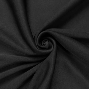 Close-up of black evening dress fabric showing fine knit texture and elegant spiral folds