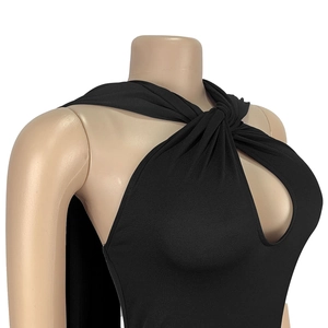 Detail of elegant black halter dress featuring a front cutout twist and draped shoulder cape