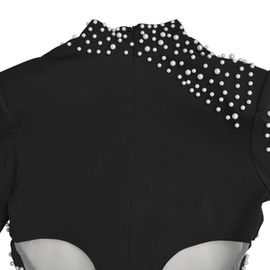 Detailed back view of a black dress featuring pearl embellishments and white mesh cutouts