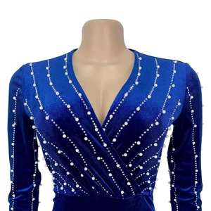 Detailed view of the dark blue velvet fabric and decorative pearls on the V-neck dress