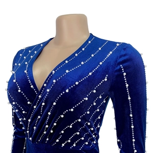 Close-up of royal blue velvet dress with deep V-neck, white pearls and shiny rhinestones
