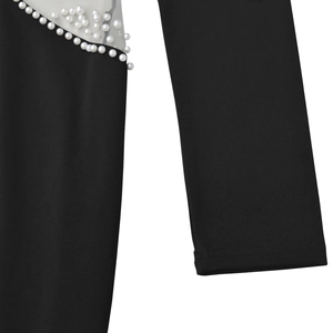 Detailed view of elegant black knit fabric with sheer mesh and white pearl embellishments