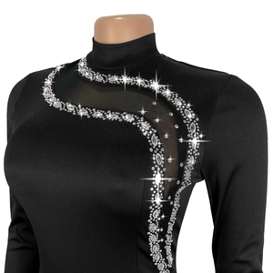 Détail de robe noire à manches longues avec découpe en maille et strass brillants
