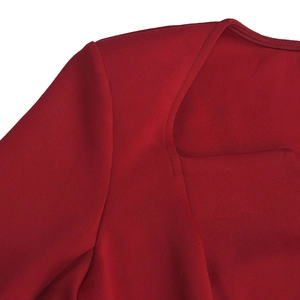 Detail view of deep red dress showing heart-shaped neckline and precision stitching