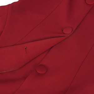 Close-up of deep red fabric texture with fabric-covered buttons and fine stitching details