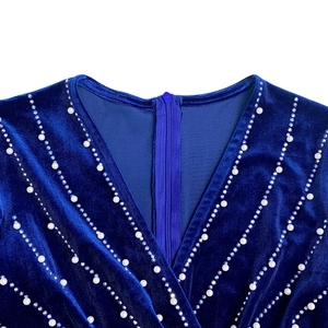 Macro detail of royal blue velvet dress with V-neckline, pearls and sparkling rhinestones