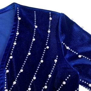 Detail of royal blue velvet fabric with sparkling rhinestones and elegant pearls