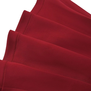 Macro shot of deep red fabric layers featuring fine ruffled edges and precise flat stitching