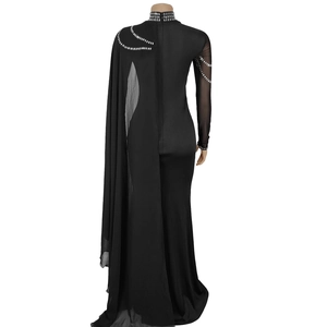Détail d'une robe noire élégante avec des strass brillants et une manche cape fluide
