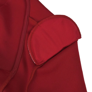 Detailed macro view of deep red dress shoulder with integrated padding and precise stitching