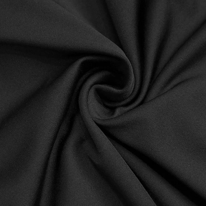Macro shot of high-quality black knitted fabric texture with elegant twisted drape effect