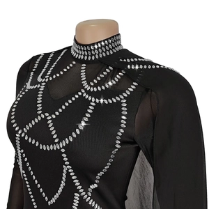 Détail d'une robe noire élégante avec maille strass et motifs cloutés argentés