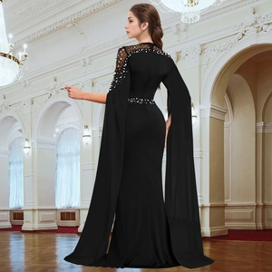 Detail of beaded pearls and sheer mesh neckline on black evening dress with cape sleeves
