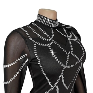 Détail d'une robe noire élégante avec manches en résille et strass scintillants géométriques