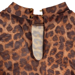 Dettaglio del top in rete leopardata con collo alto, bottoni sul retro e apertura a goccia