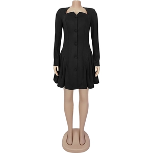 Detail of elegant black long sleeve dress featuring deep V-neck and pleated skirt detail