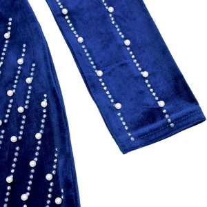 Detail of dark blue velvet dress featuring elegant pearl and rhinestone embellishments