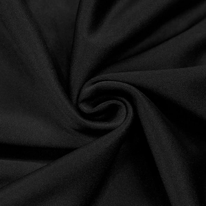Macro du tissu tricoté noir avec des drapés en spirale et un éclat subtil et soyeux
