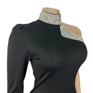Detailed close-up of rhinestone embellishments on a black off-shoulder high-neck dress