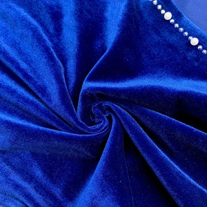 Detail of blue velvet fabric with sparkling rhinestones and white pearls decoration