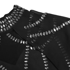 Détail macro des strass en forme de goutte et du tissu résille sur une robe noire