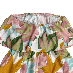 Detail of off-the-shoulder neckline with ruffles and vibrant tropical floral pattern