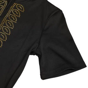 Détail de l'inscription en strass dorés sur une robe moulante noire élégante