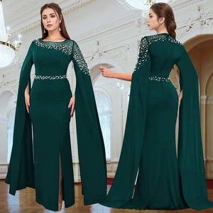 Detail of dark green evening dress featuring rhinestone beading and elegant cape sleeves