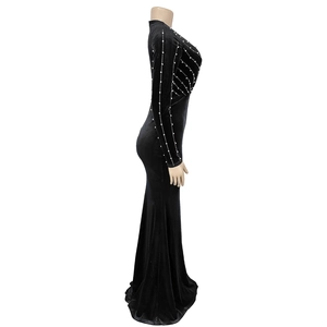 Detailed view of white pearl embellishments on black velvet long sleeve evening dress