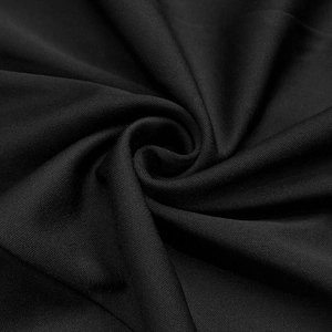 Detailed macro shot of high-quality black knitted fabric texture with spiral drape