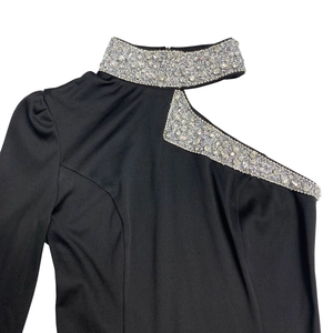 Detailed shot of sparkling silver rhinestones on a black off-shoulder dress neckline
