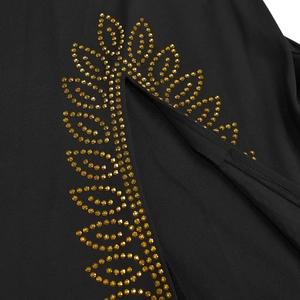 Détail d'une robe noire avec des motifs de feuilles scintillantes en strass dorés élégants