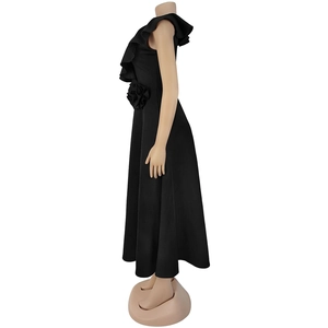 Detail of elegant black dress showing ruffle shoulder and 3D flower accent on the waist