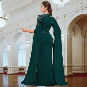 Detail of dark green evening dress with cape sleeves, pearls and rhinestone embellishments