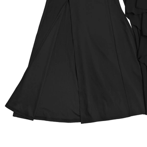 Vue détaillée d'une robe noire élégante avec volants latéraux et fente haute à l'ourlet