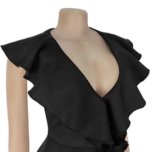 Detailed view of elegant deep V-neckline and tiered ruffles on slim black cocktail dress