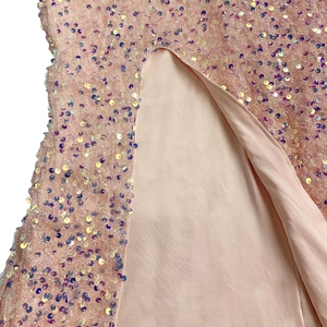 Detailed macro view of shimmering pink iridescent sequins on a dress with lining