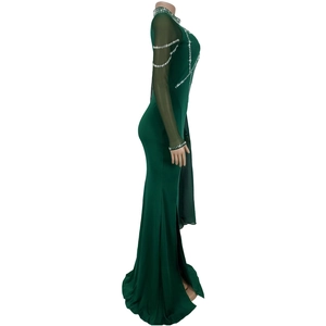 Détail d'une robe vert foncé élégante avec manches en tulle transparent et sequins